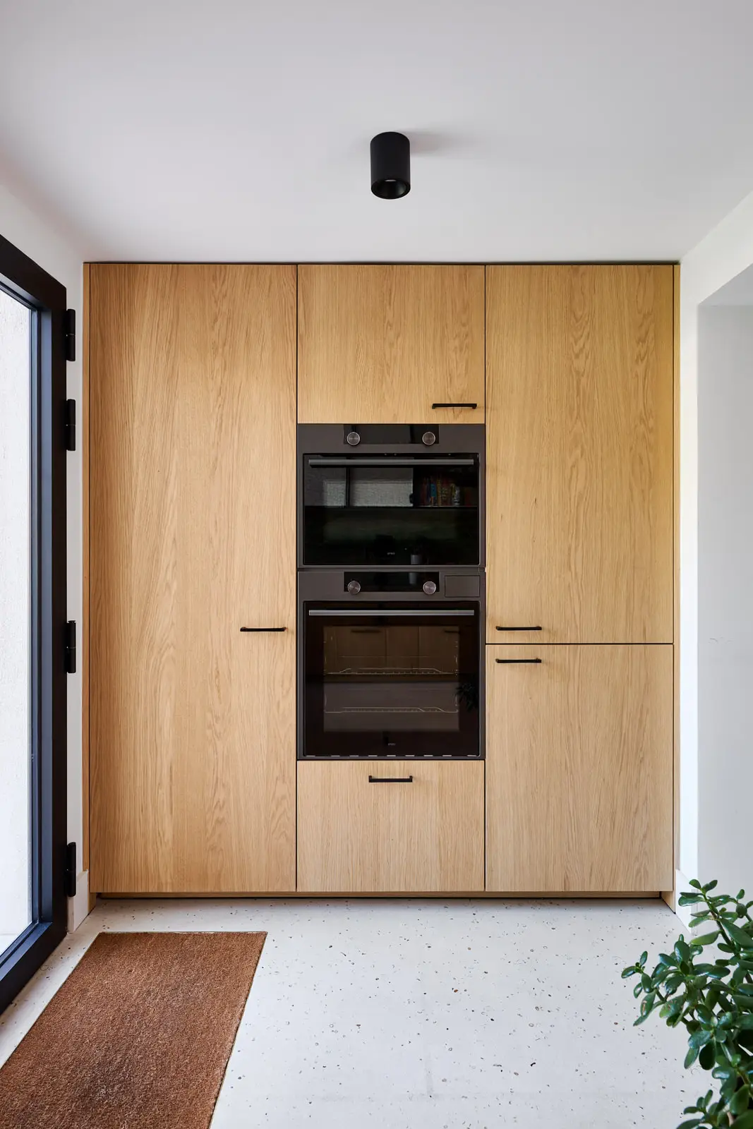 Keuken op maat in Brussel — kastenwand en eettafel in maatwerk